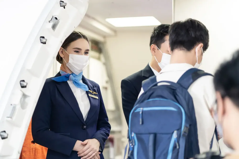 Masked flight attendant greeting passengers